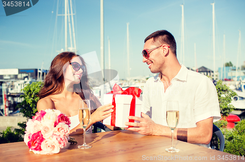 Image of smiling couple with gift box cafe