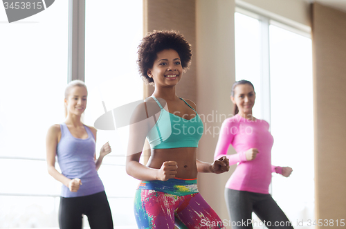 Image of group of smiling people dancing in gym or studio