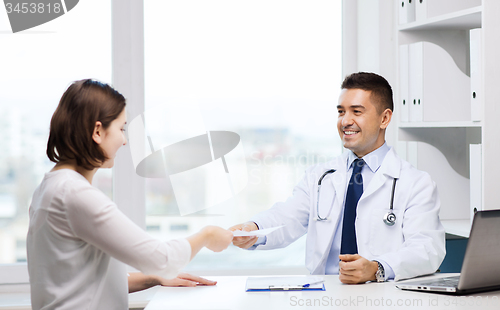 Image of smiling doctor and young woman meeting at hospital