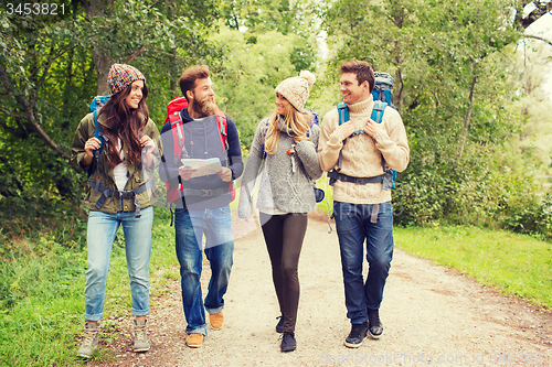 Image of group of smiling friends with backpacks hiking