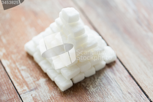 Image of close up of white sugar pyramid on wooden table