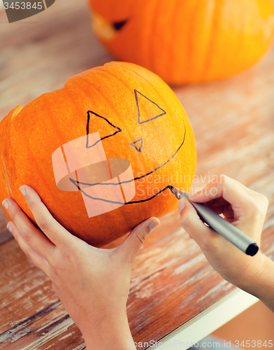 Image of close up of woman with pumpkins at home