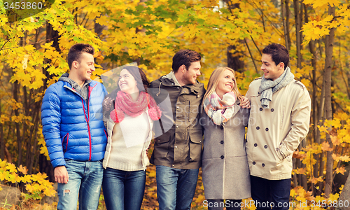 Image of group of smiling men and women in autumn park