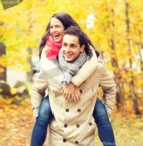 Image of smiling friends having fun in autumn park