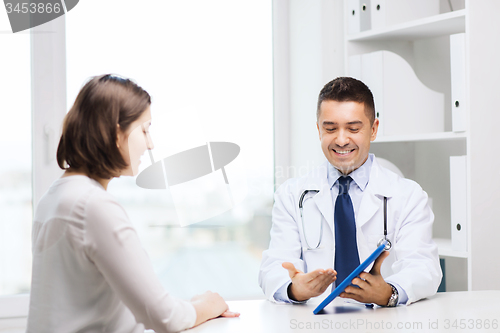 Image of smiling doctor and woman with tablet pc at clinic