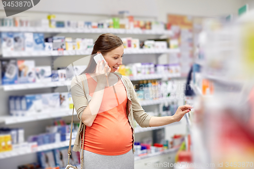 Image of happy pregnant woman with smartphone at pharmacy