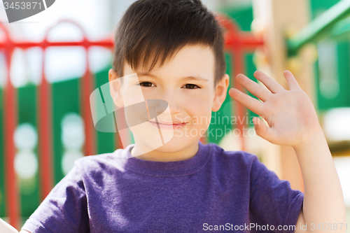 Image of happy little boy climbing on children playground