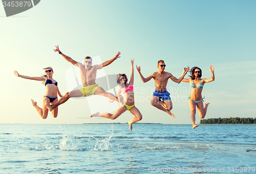 Image of smiling friends in sunglasses on summer beach