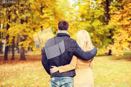 Image of couple hugging in autumn park from back