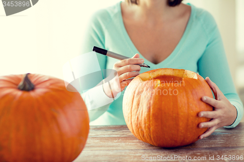 Image of close up of woman with pumpkins at home