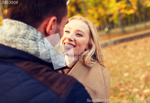 Image of smiling couple hugging in autumn park