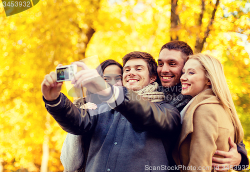 Image of group of smiling men and women making selfie