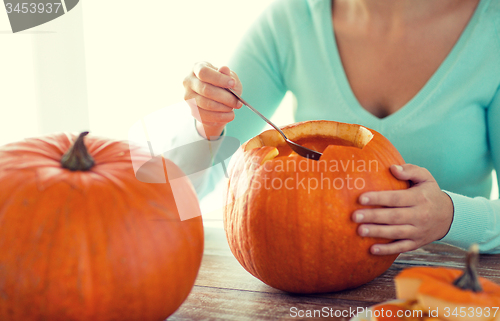 Image of close up of woman with pumpkins at home