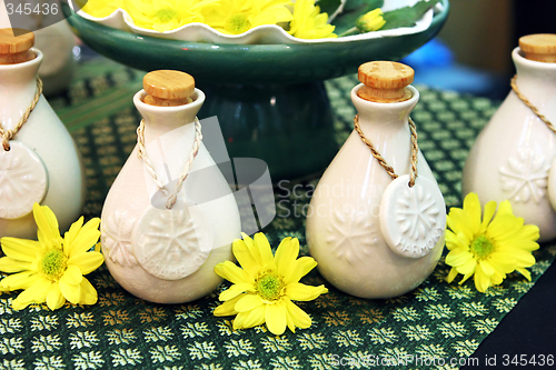 Image of Bottles of herbal spa oils and flowers.