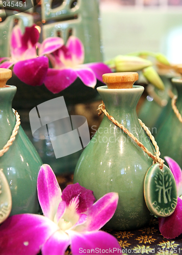 Image of Bottles of herbal spa oils and flowers.