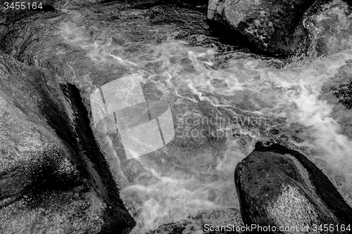 Image of river stream flowing over rock formations in the mountains