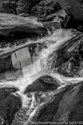 Image of river stream flowing over rock formations in the mountains