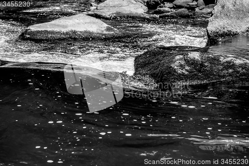 Image of river stream flowing over rock formations in the mountains