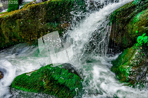 Image of river stream flowing over rock formations in the mountains