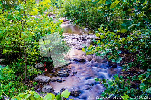 Image of river stream flowing over rock formations in the mountains