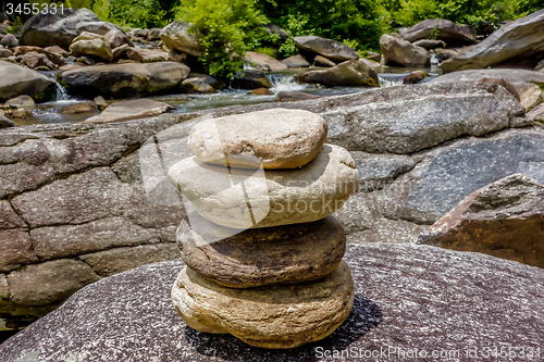 Image of Stack of round smooth stones near mountain river