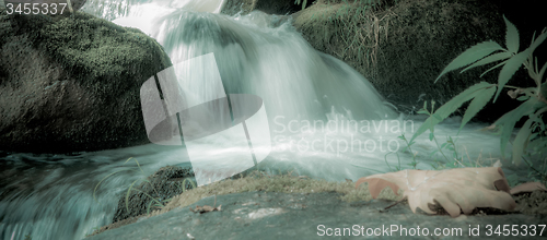 Image of river stream flowing over rock formations in the mountains