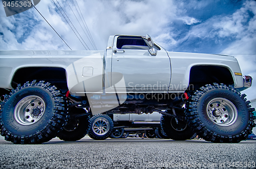 Image of huge truck with huge wheels at a classic car show in a small tow