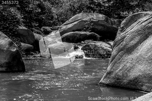 Image of river stream flowing over rock formations in the mountains