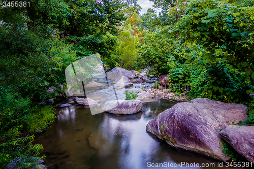 Image of river stream flowing over rock formations in the mountains