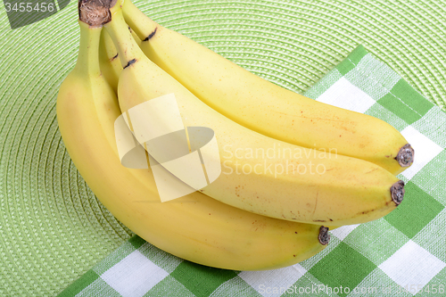 Image of Bunch of ripe bananason green material background