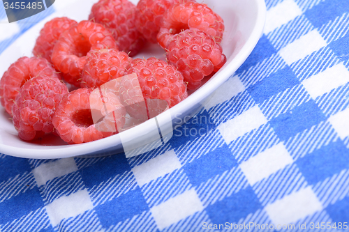 Image of Fresh raspberries. Closeup of fruits on a white plate