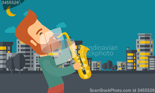 Image of Saxophonist playing in the streets at night