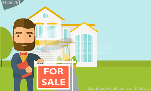 Image of Real estate agent standing beside the for sale placard.