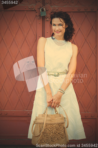 Image of Smiling beautiful middle-aged woman in a white dress