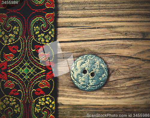 Image of old band with embroidered ornaments and vintage button