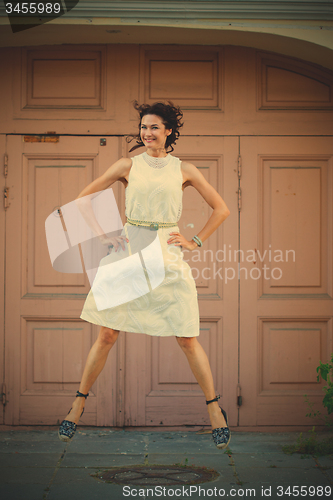 Image of Smiling beautiful middle-aged woman in the white dress flying