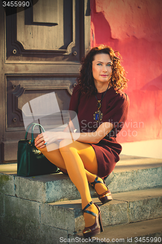 Image of beautiful middle-aged woman in a burgundy dress