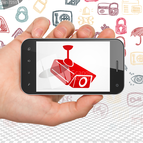 Image of Privacy concept: Hand Holding Smartphone with Cctv Camera on display