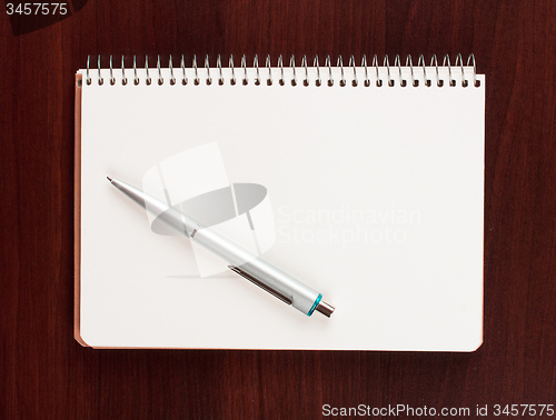 Image of pen and blank paper on wood