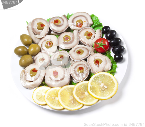 Image of fish slices served with tomato and olives