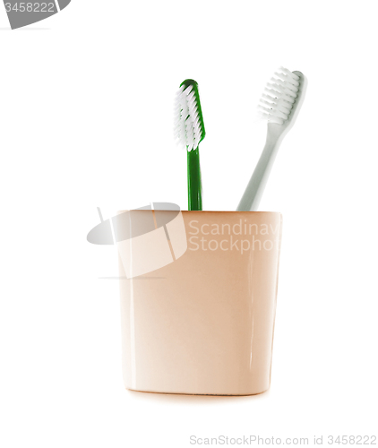 Image of Two toothbrushes in glass