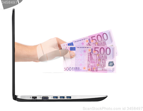 Image of hand with money comes from laptop screen isolated on white