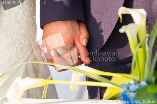 Image of Wedding couple holding hands.