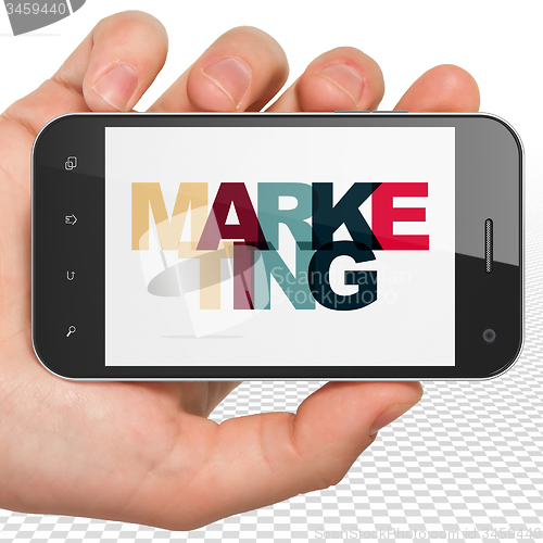 Image of Marketing concept: Hand Holding Smartphone with Marketing on  display