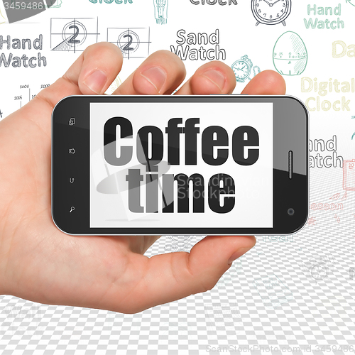 Image of Timeline concept: Hand Holding Smartphone with Coffee Time on display