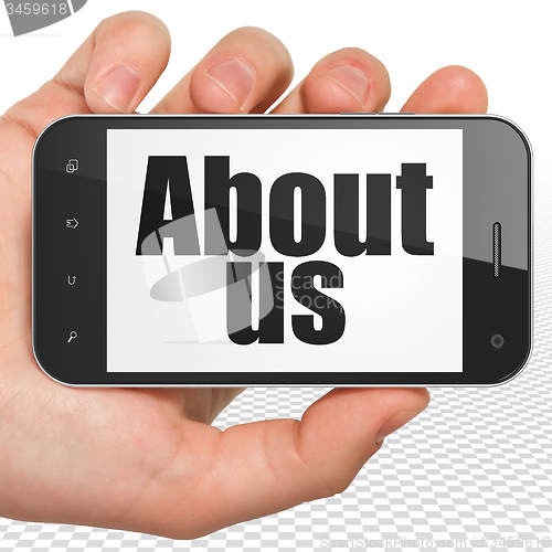 Image of Marketing concept: Hand Holding Smartphone with About Us on display