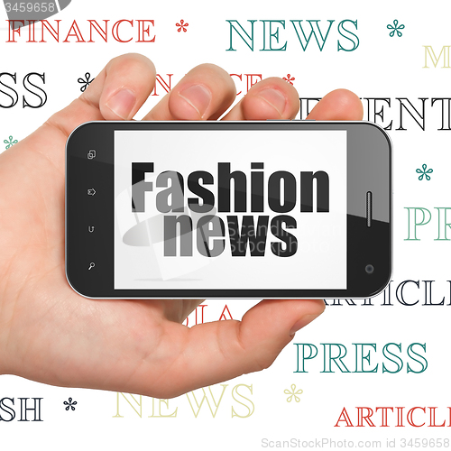 Image of News concept: Hand Holding Smartphone with Fashion News on display