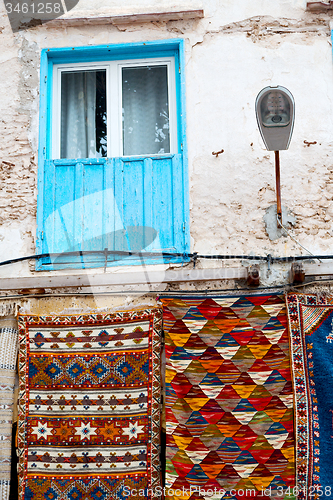 Image of blue window in  africa and brown wall red carpet