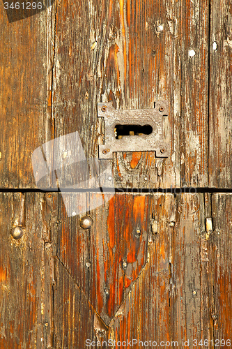 Image of  red abstract  house door    in italy         closed nail rusty