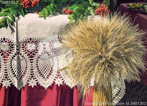 Image of A sheaf of wheat on a background of lace fabric.